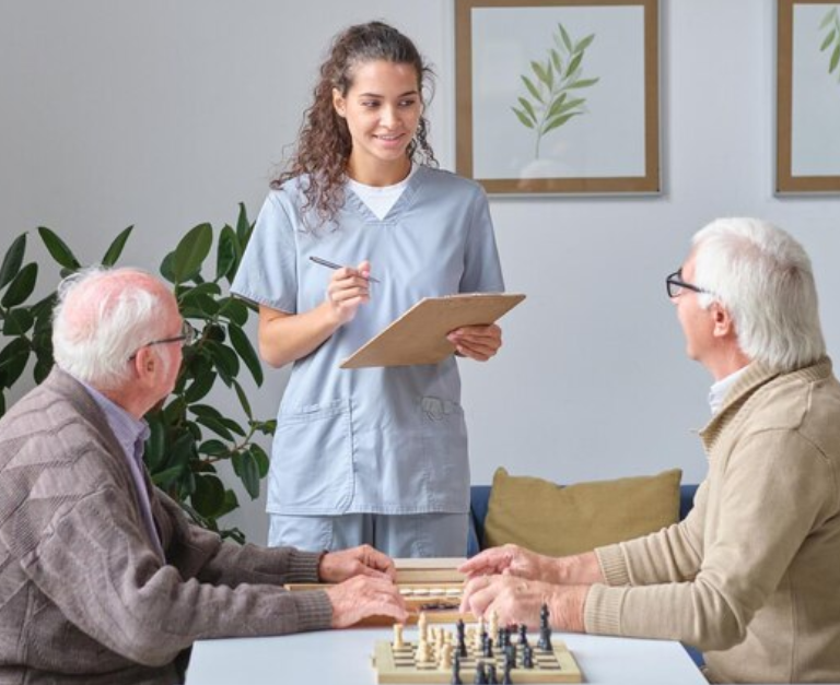 Nurse talking to senior men in nursing home