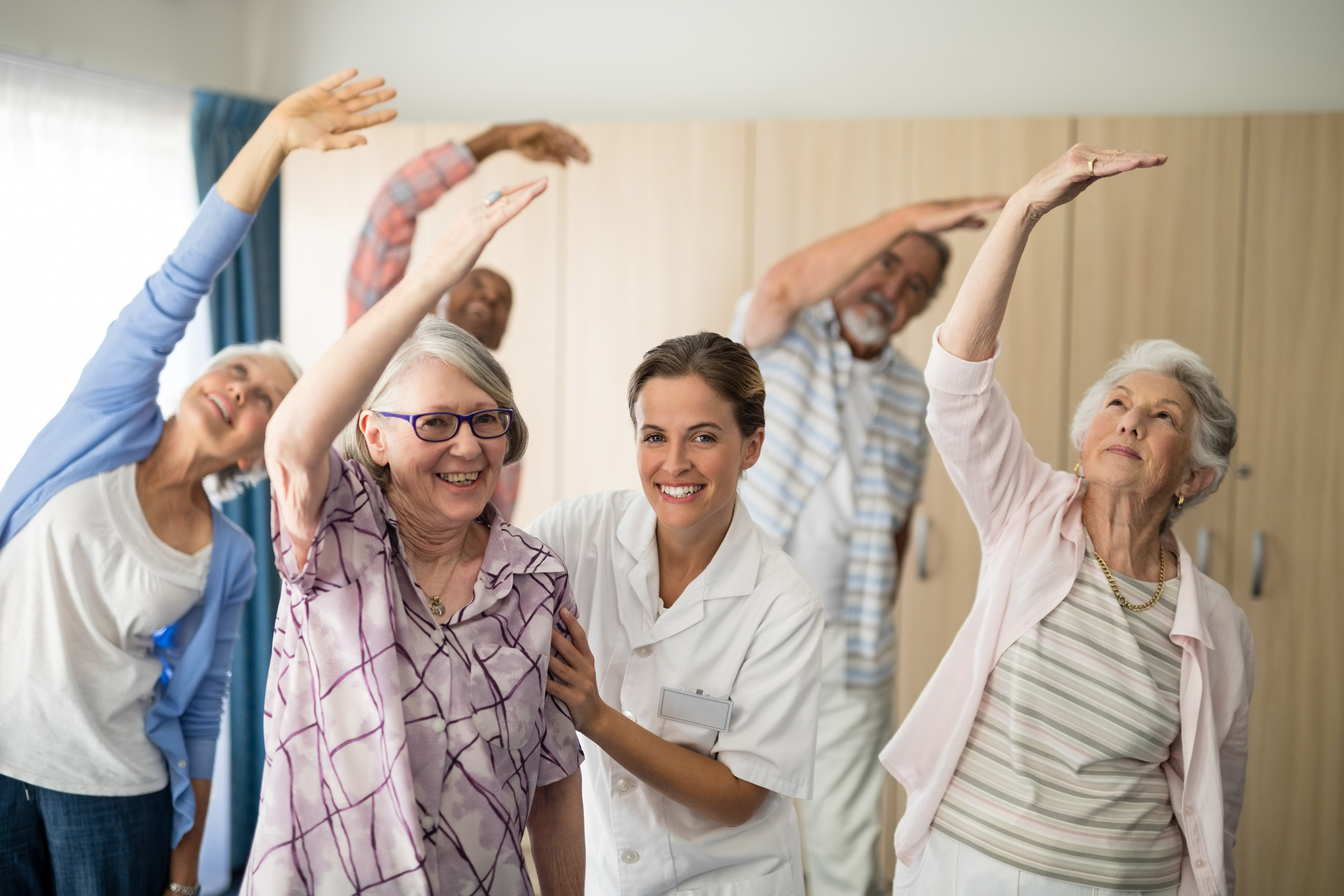 Portrait of smiling female doctor assisting senior woman exercising Portrait of smiling female doctor assisting senior woman exercising