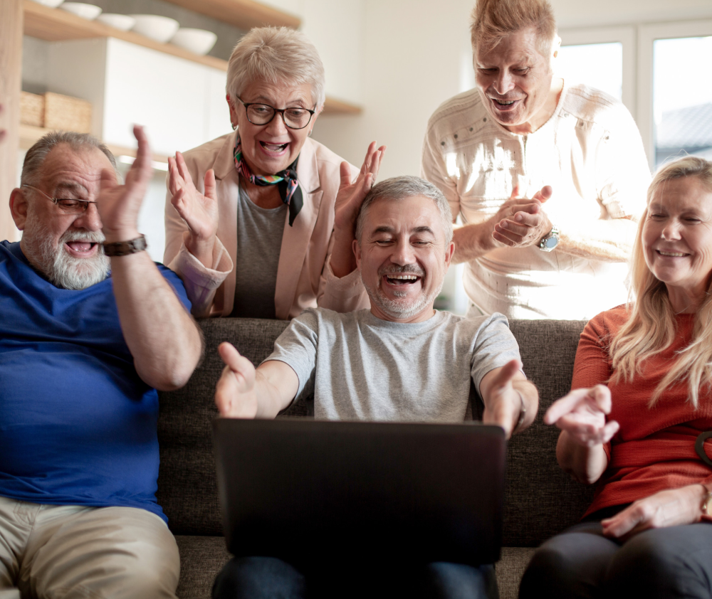 group of old friends watch a video on their laptop